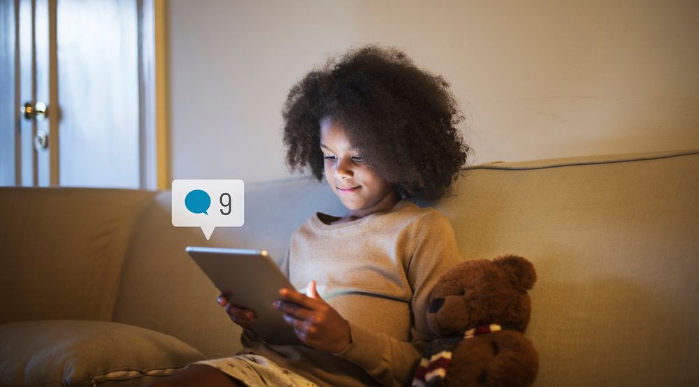 Young girl using a digital tablet before bedtime