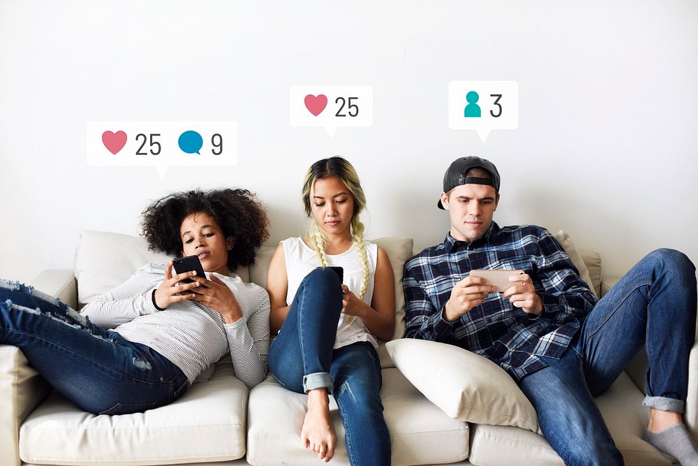 Young adults on the couch using social media on their smartphones