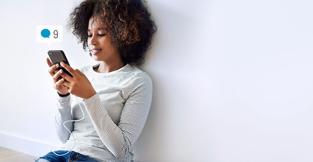 Happy black woman using social media on her smartphone