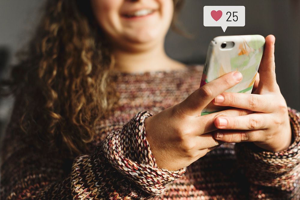 Teenage woman using social media on her smartphone