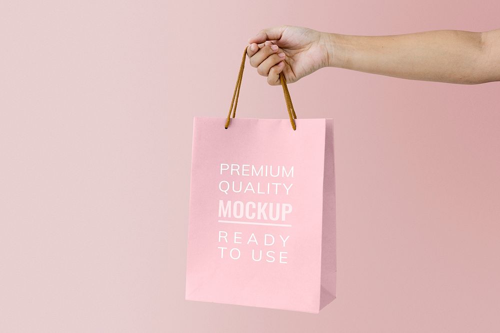 Woman holding a pink paper bag mockup