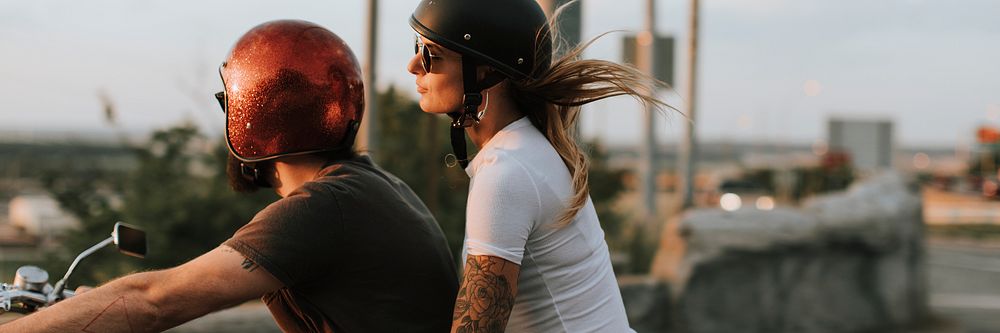 Biker couple riding down the road in the sunset