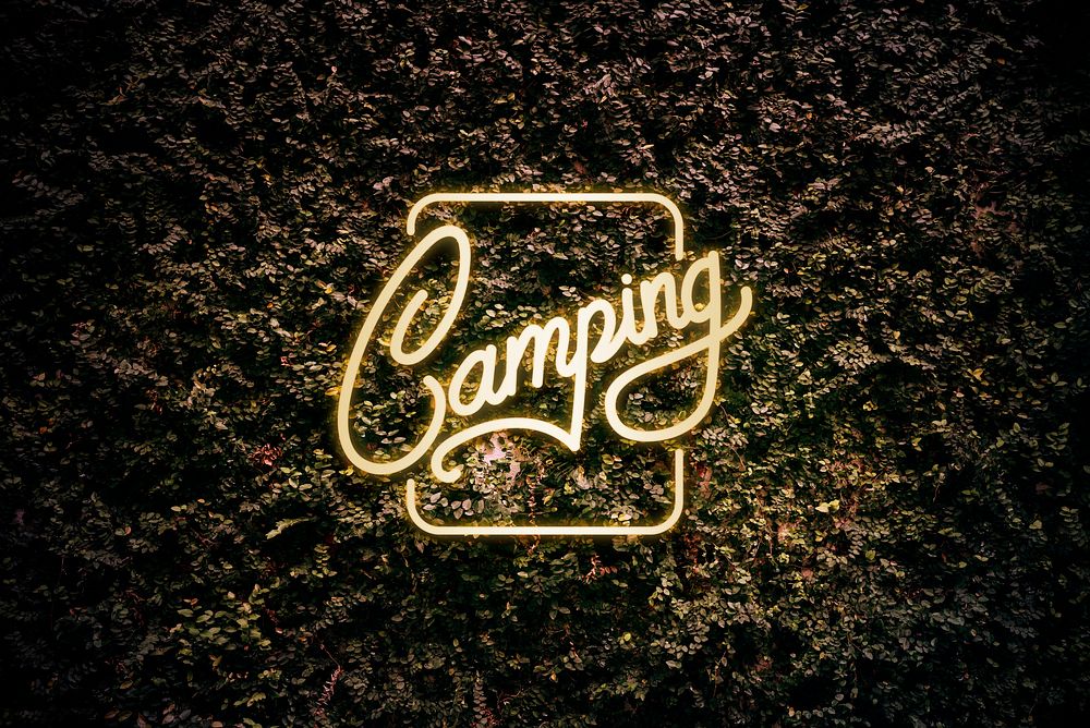 Neon yellow camping sign on a leaves background