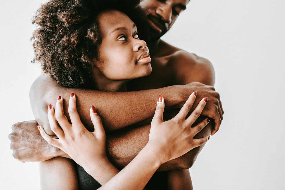 Seminude black couple holding each other
