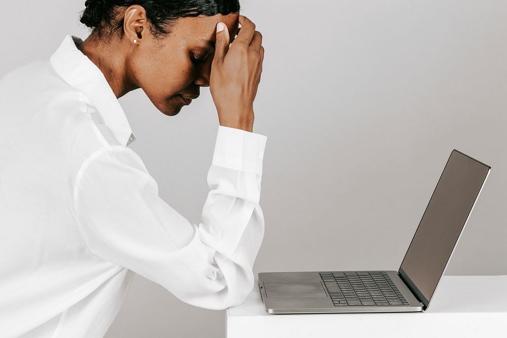 Black woman getting stressed while working on laptop