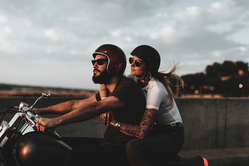 Biker couple riding during sunset