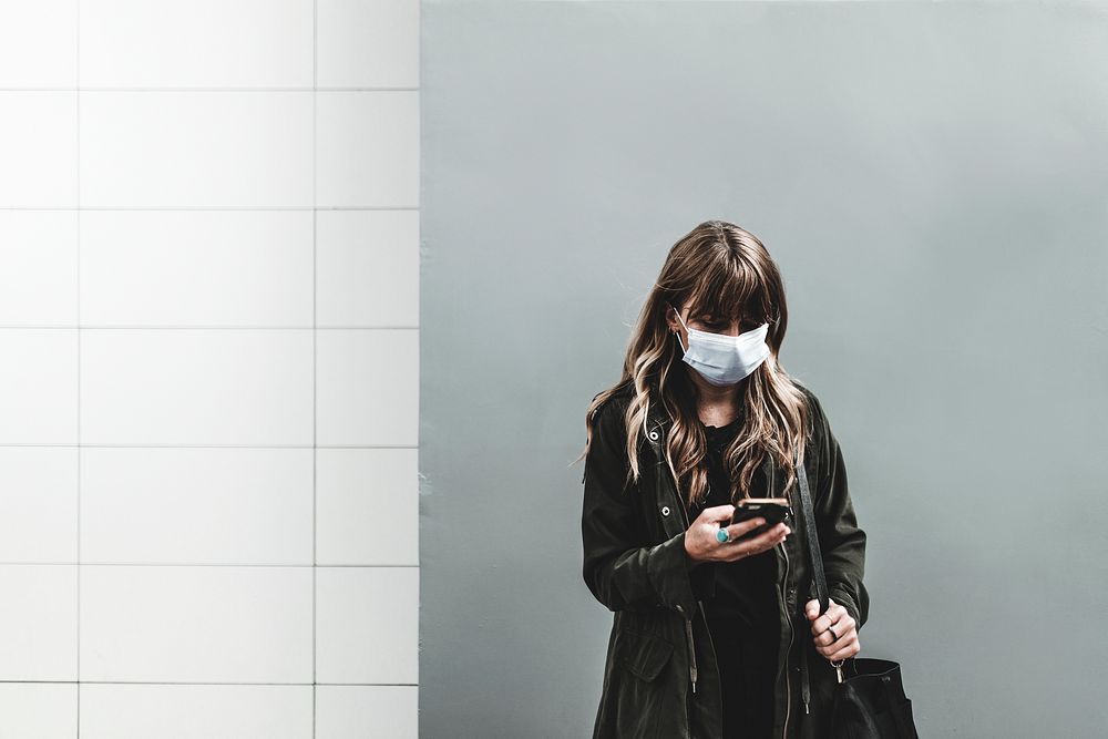 Woman with face mask, using phone in public