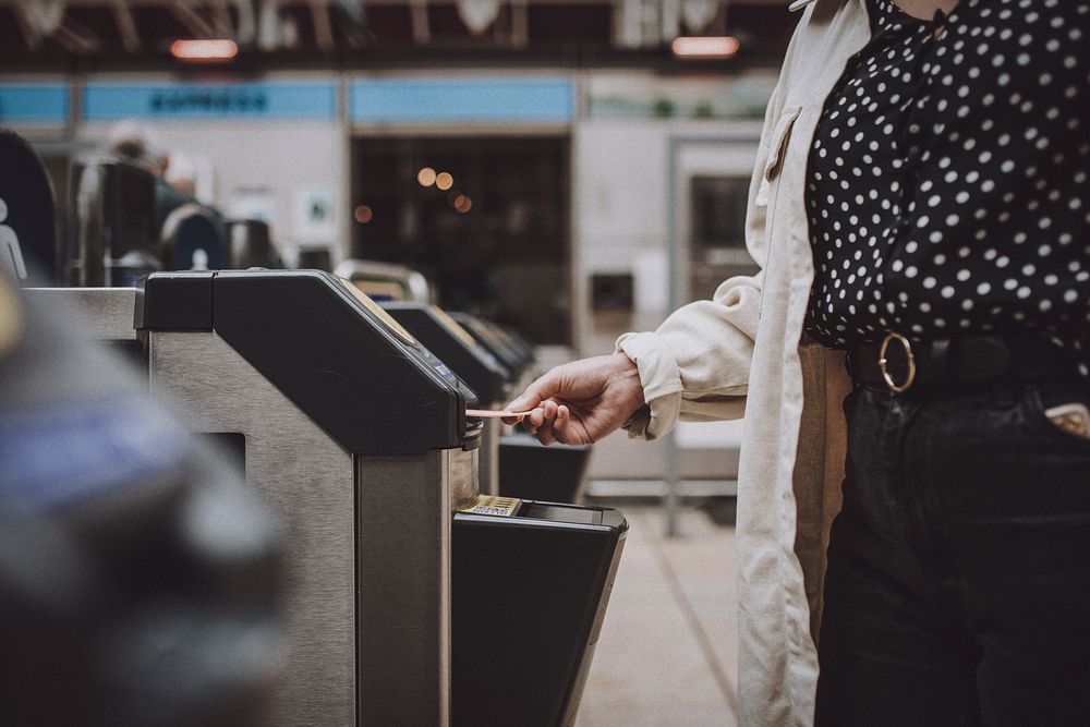 Woman with ticket at train station turnstile