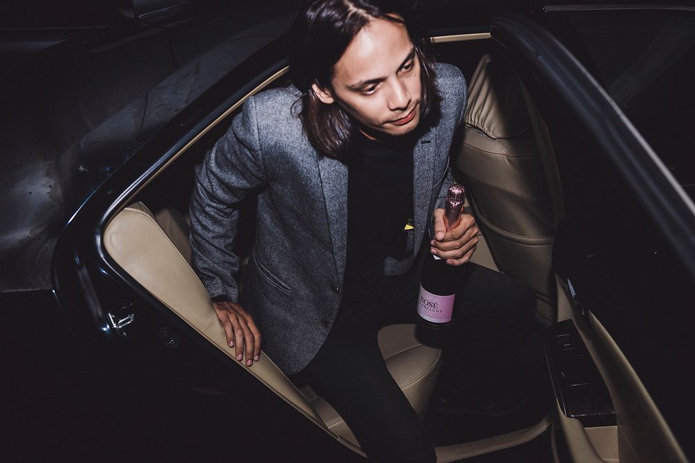 Man leaving car with rose champagne