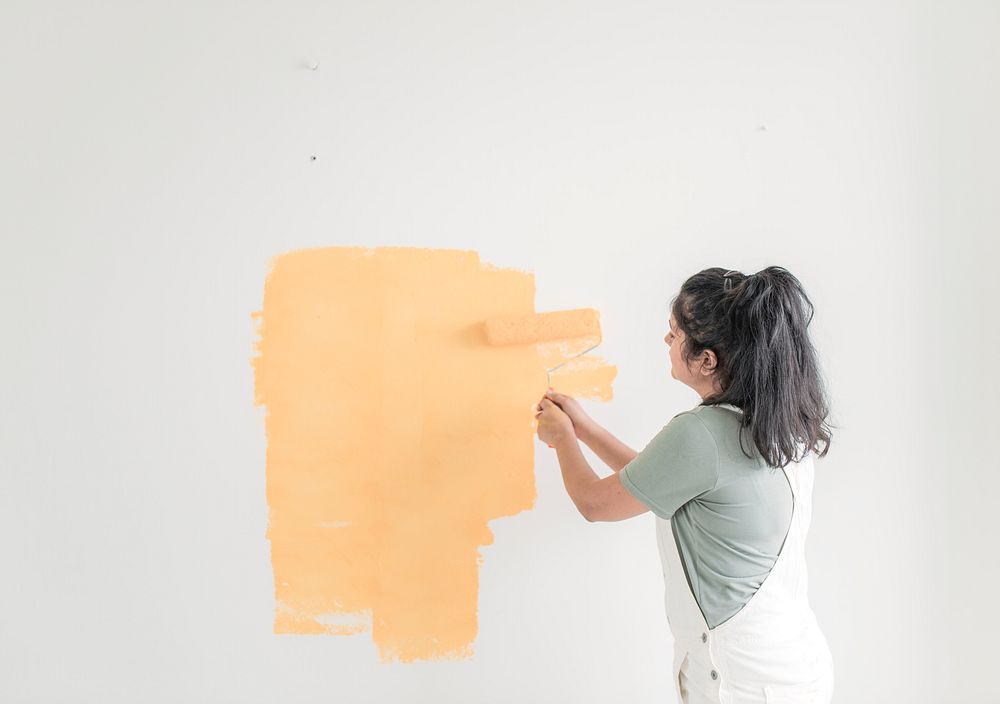 Woman painting her wall, home DIY