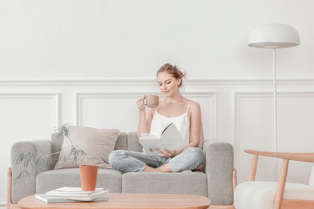 Woman reading while having tea in minimal living room
