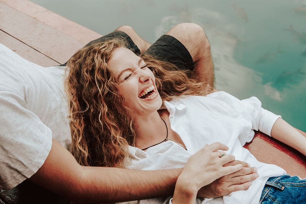 Happy woman lying on her boyfriend's laps