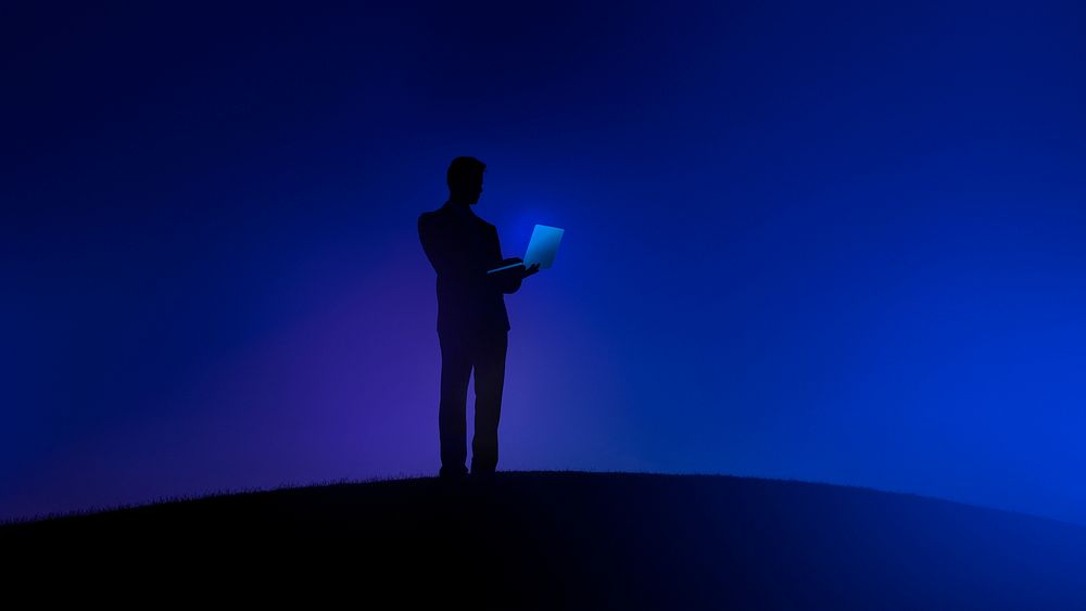 Businessman holding a laptop on a blue background