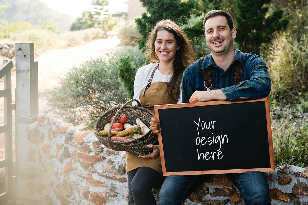 Farmer couple holding a vegetable basket and a blackboard mockup