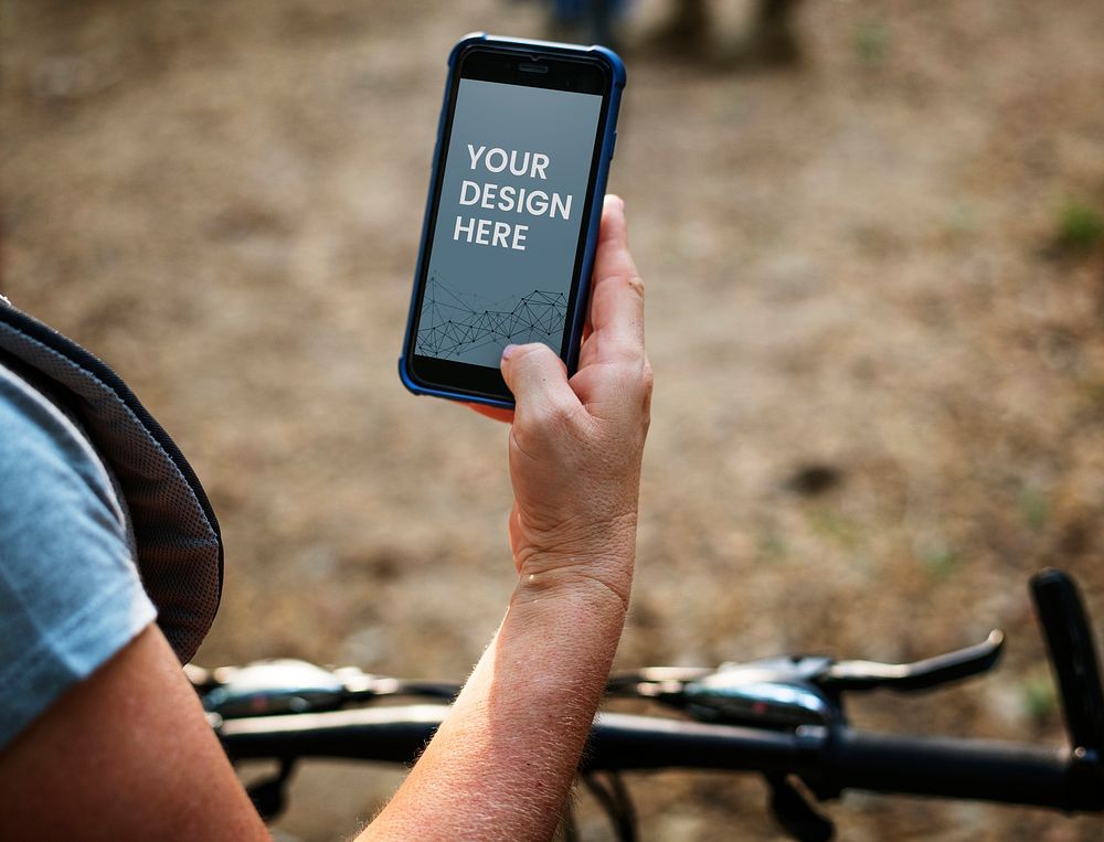 Female cyclist holding a phone mockup