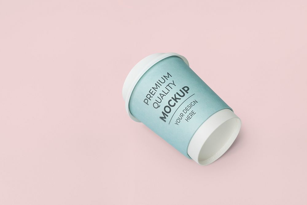 Coffee to go cup with a blue sleeve mockup on a pink background