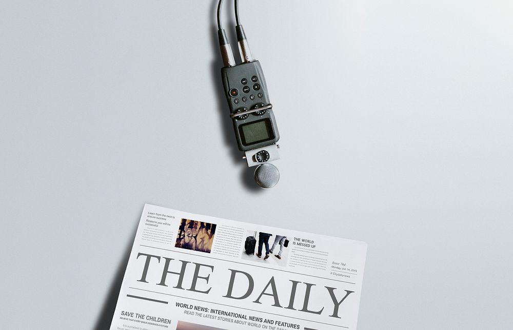 Portable sound recorder and a newspaper on a table
