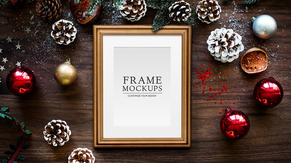 Classic gold frame mockup with Christmas decorations on wooden background