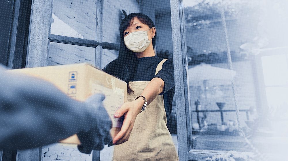 Woman in a face mask receiving a delivery box