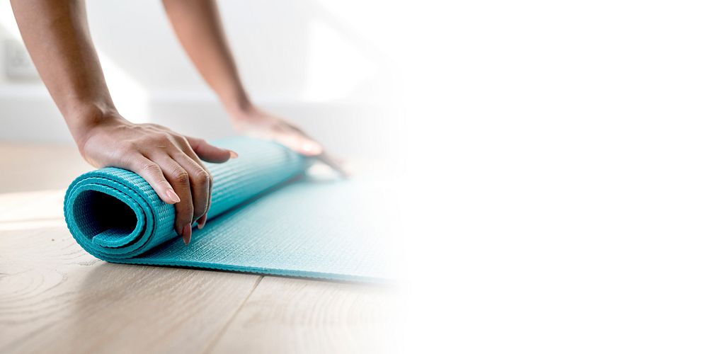 Woman rolling up a yoga mat during coronavirus quarantine