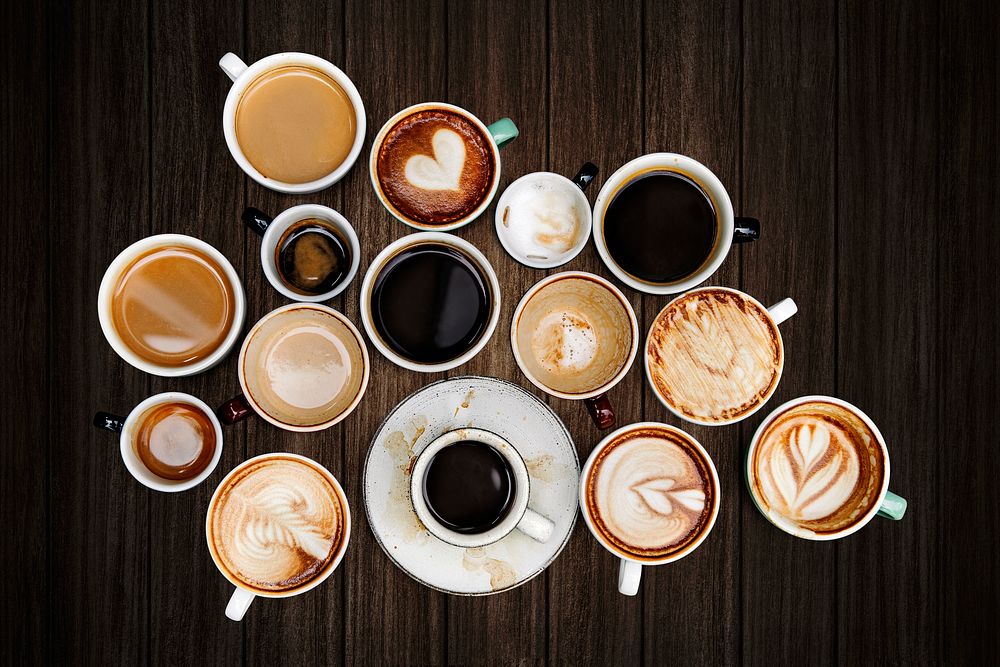 Various coffee cups on a dark brown wooden textured background