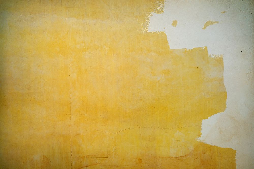 Yellow paint on a cracked concrete wall background