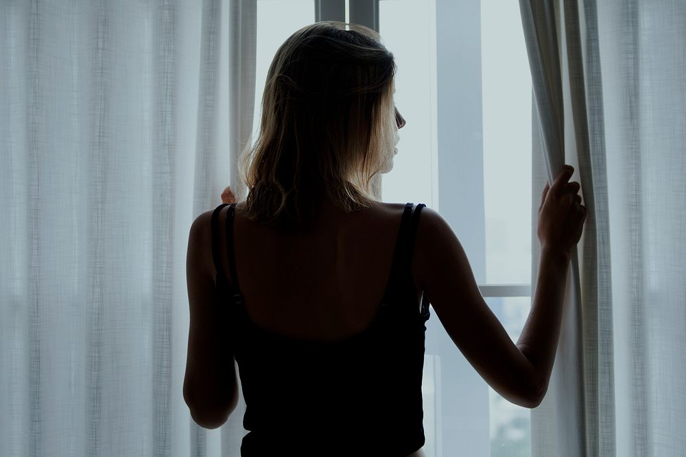 Rear view of a woman standing by the window