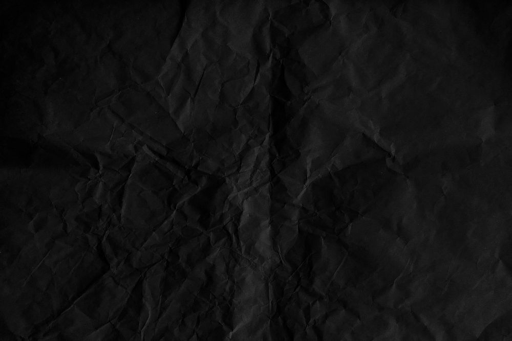 Crumpled black paper textured background