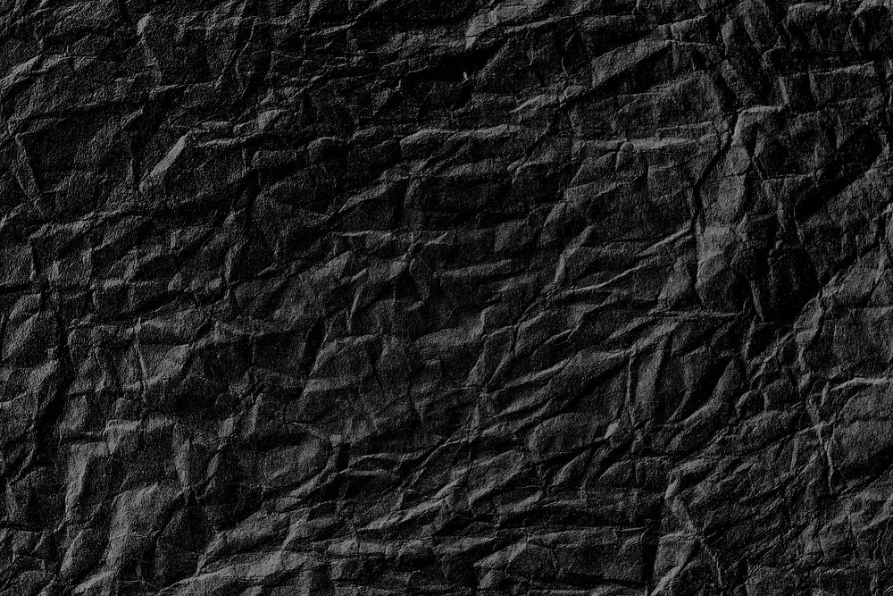 Crumpled black paper textured background