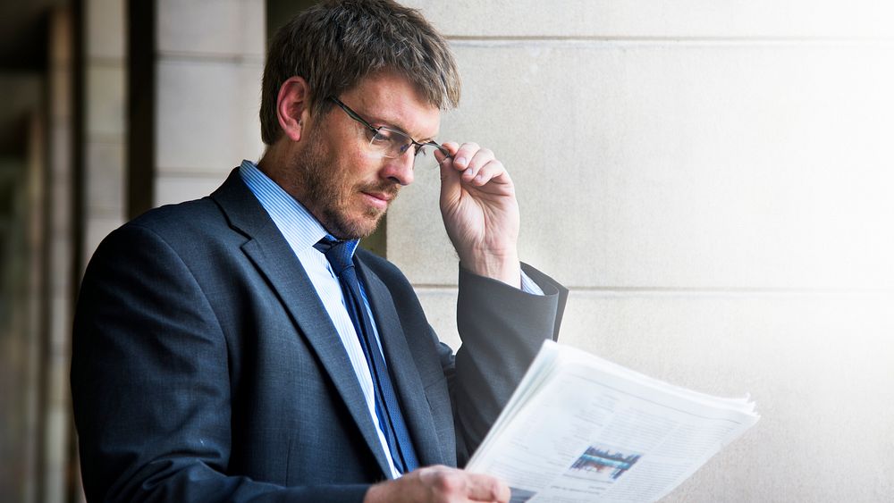 Businessman reading a marketing newspaper