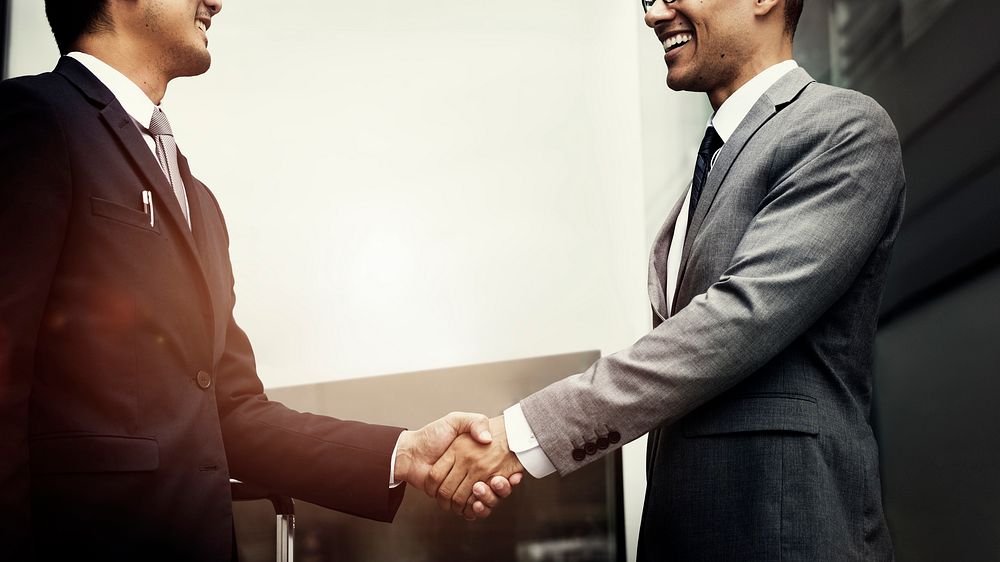 Two corporate businessmen shaking hands
