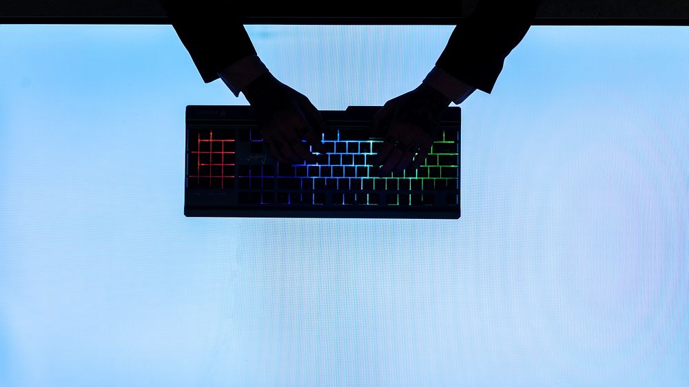 Silhouette of hands typing keyboard