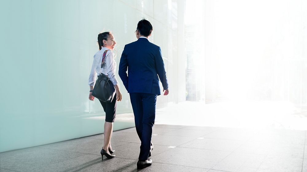 Asian business couple talking while walking