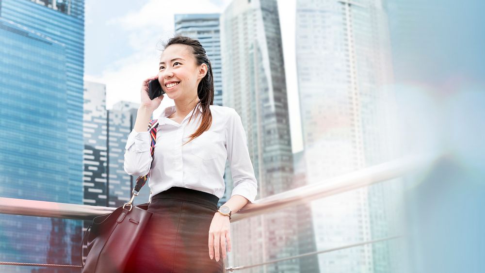 Asian businesswoman talking on a phone in a city