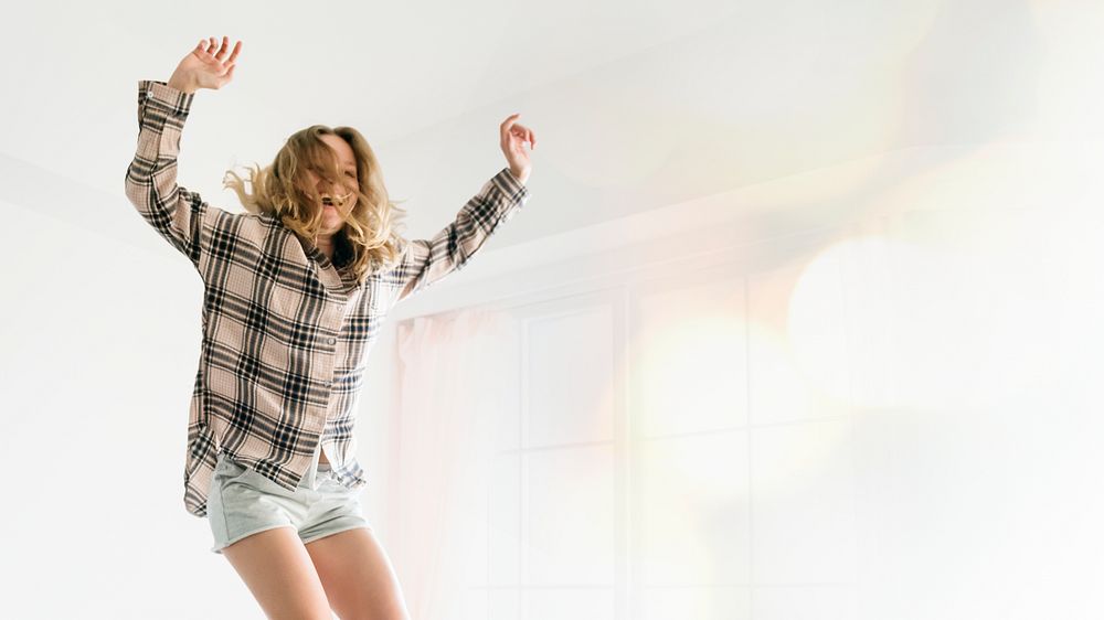 Woman jumping with joy on her bed