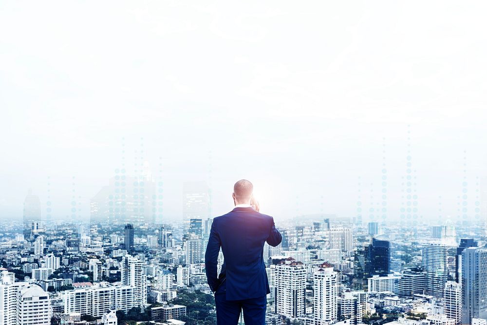 Rear view of a businessman talking on the phone on top of the building