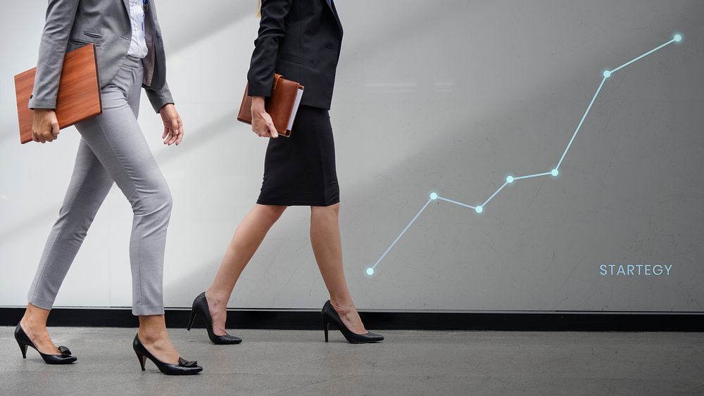 Two businesswomen walking with a growth graph