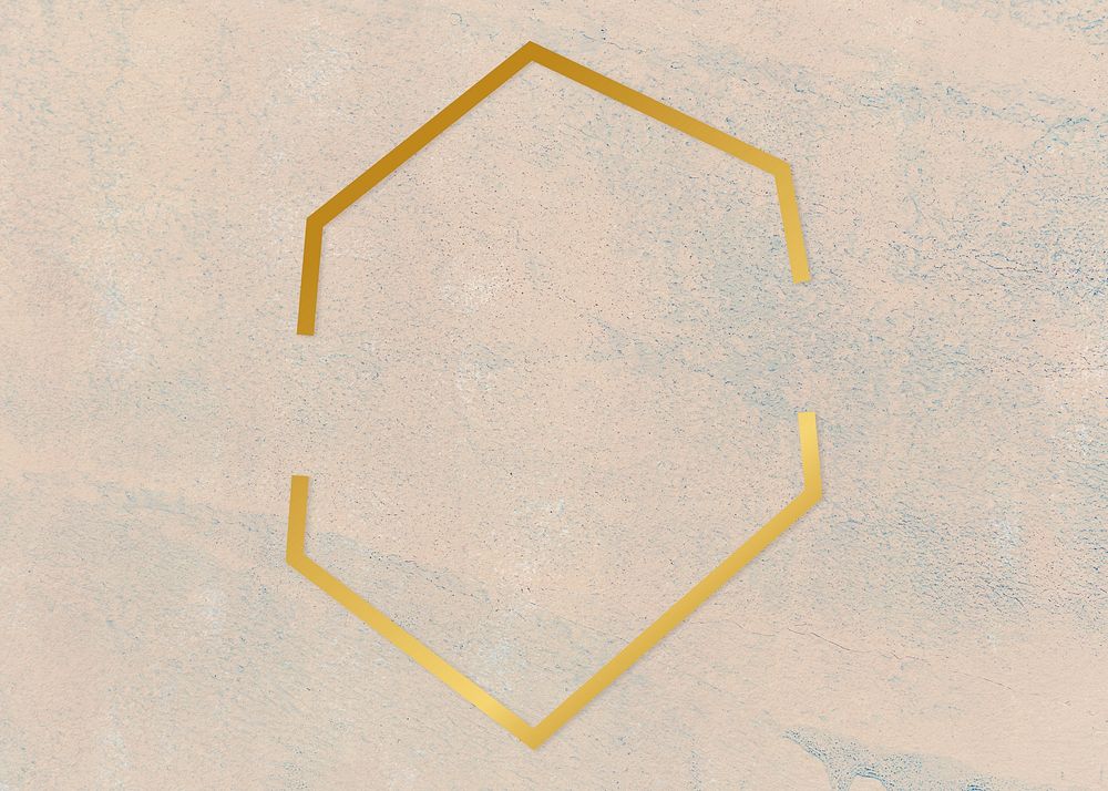 Gold hexagon frame on a rough beige background