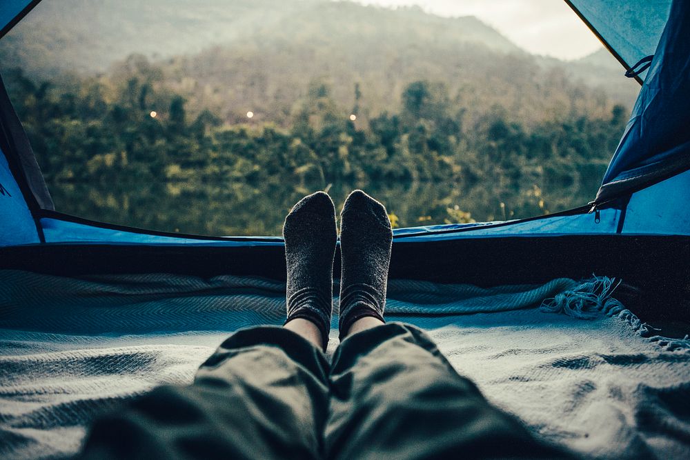 Camper enjoying natural view from inside tent