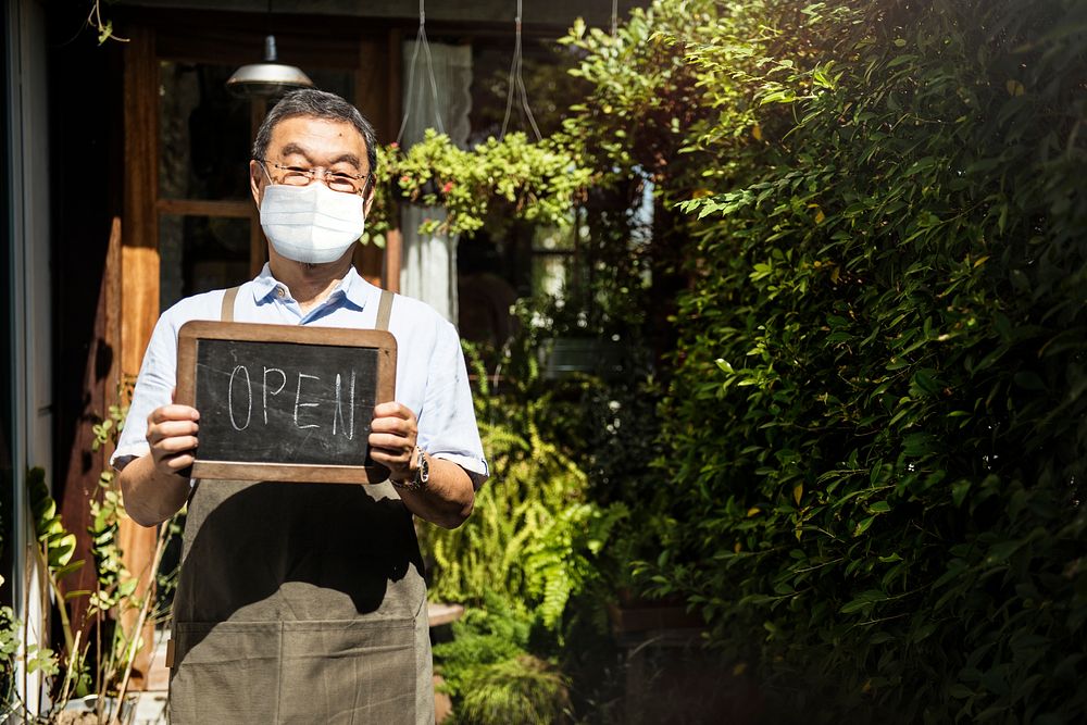 Japanese shop owner in face mask new normal post covid 19