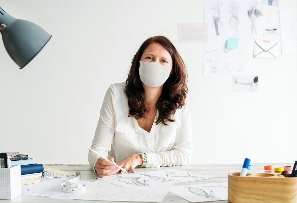 Designer in a mask in new normal office workplace 
