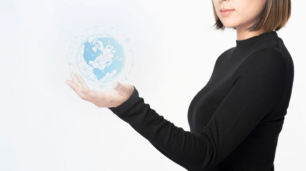 Businesswoman holding a high digitally generated globe