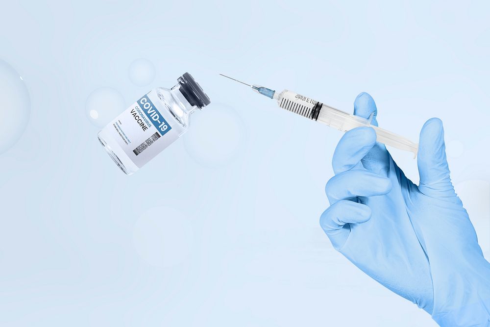Hand holding syringe and vaccine vial