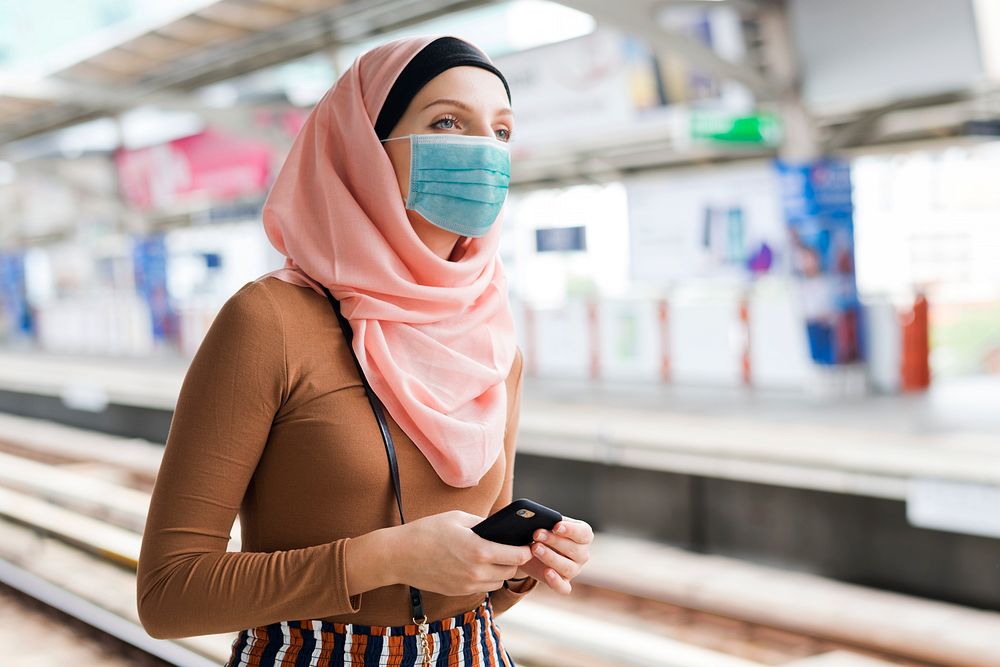Muslim woman with mask on the train platform