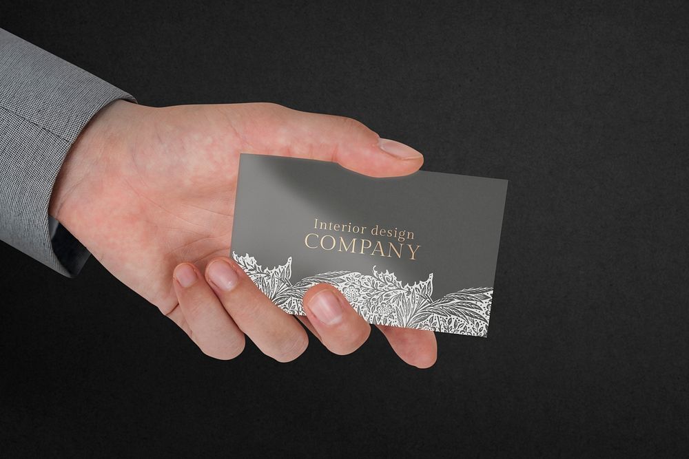 Floral business card mockup psd with businessman’s hand