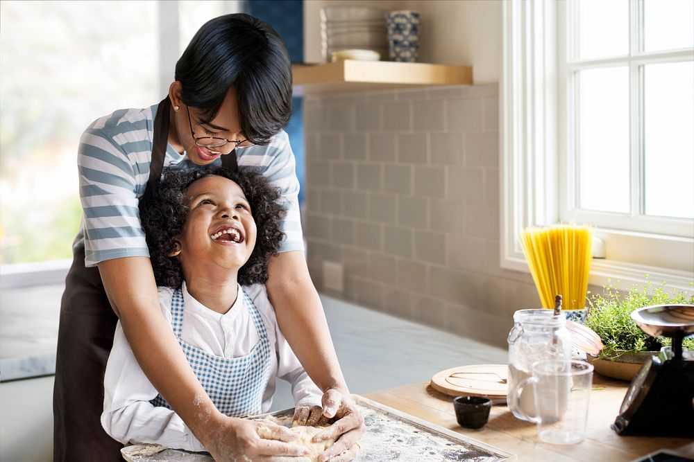 Young boy learning to bake with his mother