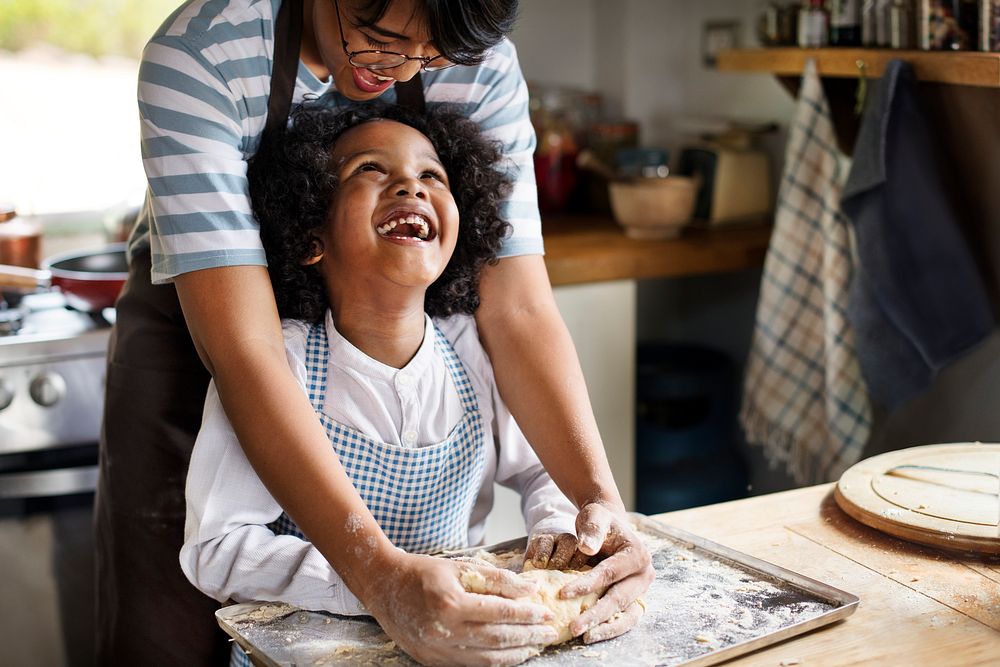 Young boy learning to bake with his mother