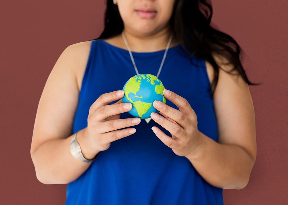 Portrait of a woman holding a small globe