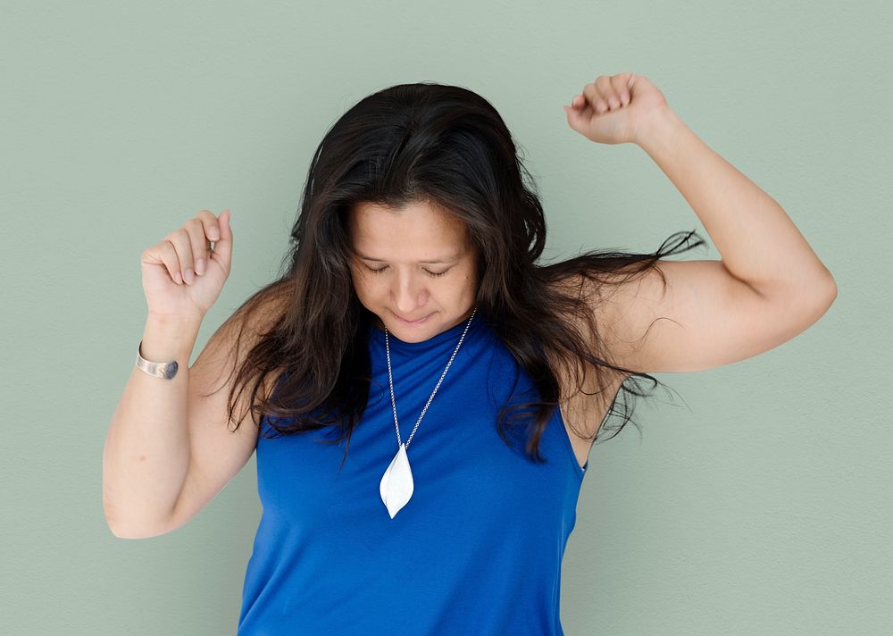 Portrait of a woman with eyes closed and arms raised