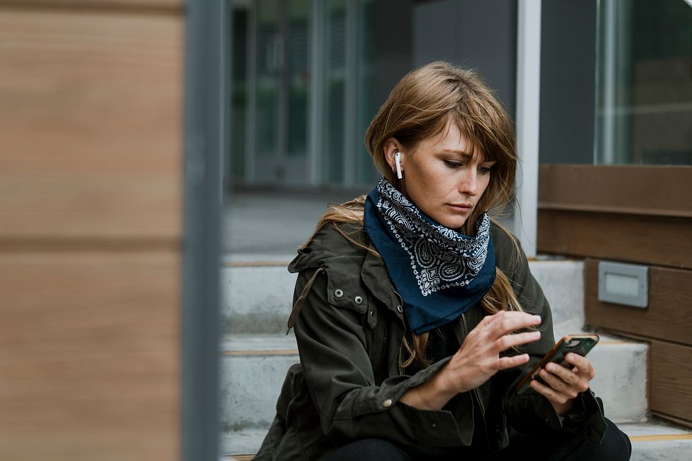 Woman using her phone on a steps